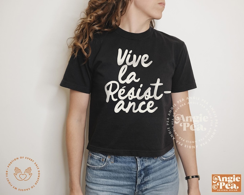 May include: A black cropped t-shirt with the text "Vive la Resist-ance" in white lettering. The shirt is being worn by a person with long brown hair.