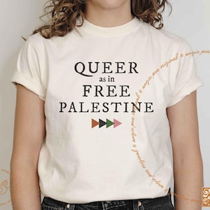 May include: A white t-shirt with the text "QUEER as in FREE PALESTINE" in black lettering. A row of colorful geometric shapes are below the text.