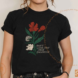 May include: Black t-shirt with a floral design and the text "Don't Look Away From Palestine".