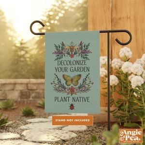 May include: A green garden flag with a floral design and the text "Decolonize Your Garden Plant Native". A bee, butterfly, and ladybug are featured in the design. The text "Stand Not Included" is printed below the flag.