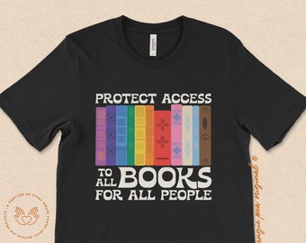Könnte beinhalten: Schwarzes T-Shirt mit dem Text "PROTECT ACCESS TO ALL BOOKS FOR ALL PEOPLE" in Weiß. Hinter dem Text befindet sich ein Stapel bunter Bücher mit regenbogenfarbenen Rückseiten.