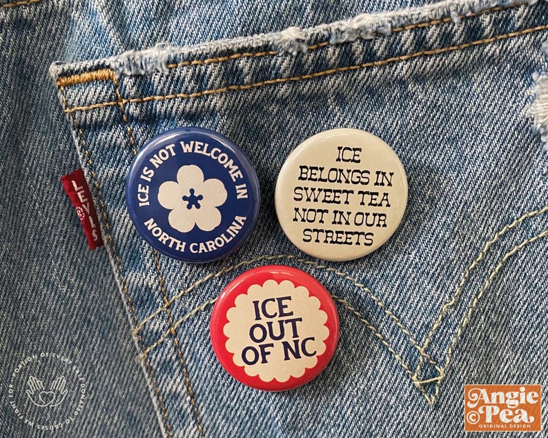 May include: Three round pinback buttons with text and graphics are displayed on a denim background. The buttons have the phrases "ICE IS NOT WELCOME IN NORTH CAROLINA", "ICE BELONGS IN SWEET TEA NOT IN OUR STREETS", and "ICE OUT OF NC".