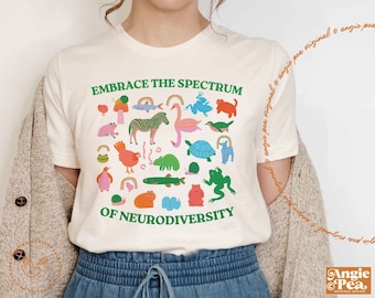 May include: White t-shirt with a colourful graphic design featuring animals and the text "Embrace the Spectrum of Neurodiversity".