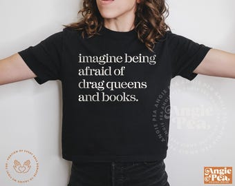 May include: Black cropped t-shirt with white text that reads "imagine being afraid of drag queens and books."