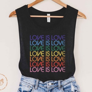 May include: A black sleeveless tank top with the phrase "LOVE IS LOVE" repeated in rainbow colors.