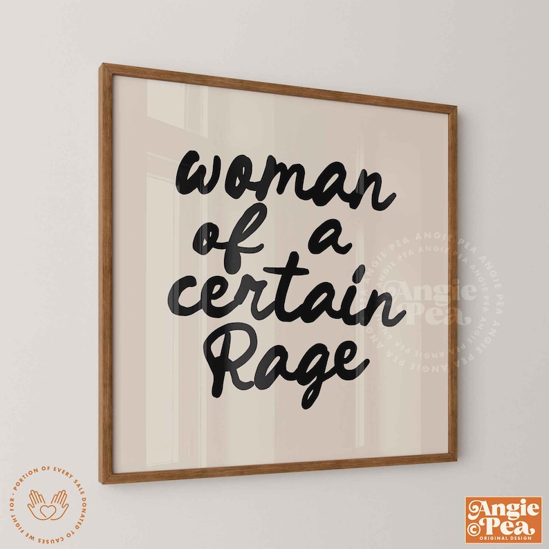 May include: A framed print with the words "woman of a certain Rage" in black script. The artwork has a beige background and a brown wooden frame. The lower right corner has the Angie Pea logo.
