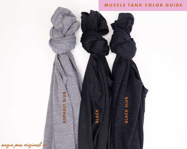 May include: Three muscle tank tops in different colors: asphalt slub, black, and black slub. The tank tops are folded and tied in a knot.