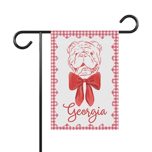 May include: A red and white gingham garden flag with a red bulldog illustration wearing a red bow and the word "Georgia" in red lettering.