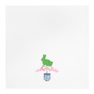 May include: A green topiary shaped like a bunny rabbit with a pink ribbon tied around the base. The topiary is in a blue and white ceramic pot.