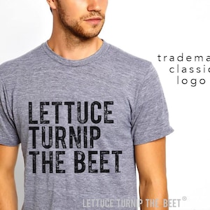 May include: A heather gray t-shirt with a black graphic that reads "Lettuce Turnip The Beet" in a vintage style font. The text is centered on the shirt and is the only design element.