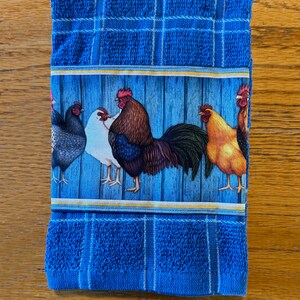 Leuchtend blaues Küchentuch mit bunten Hühnern