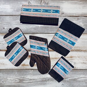 May include: Set of kitchen towels and pot holders with a blue, white, and orange geometric pattern. The towels and pot holders are made of a dark brown fabric.