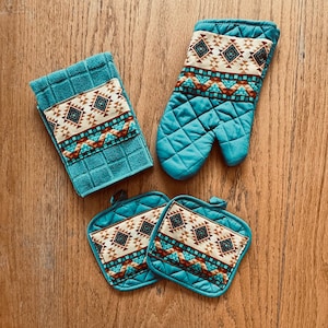 Könnte beinhalten: Set aus vier Küchenaccessoires in Tealblau mit einem geometrischen Muster in Braun und Beige. Das Set beinhaltet einen Topflappen, zwei Topfuntersetzer und einen Ofenhandschuh.