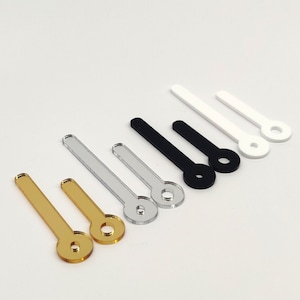 Può includere: Assortimento di lancette per orologi in oro, argento, nero e bianco. Le lancette sono in acrilico e hanno una forma circolare all'estremità.