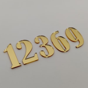 Op de afbeelding: Gouden spiegelachtige acrylcijfers 1, 2, 3, 6 en 9.