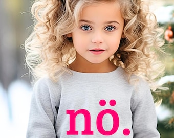 May include: A young girl with blonde, curly hair and blue eyes is wearing a gray sweatshirt. The sweatshirt has the word "nö." printed in bright pink. She is also wearing a silver glitter headband.