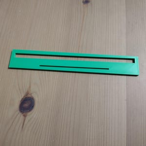May include: A bright green plastic ruler with a single line etched into the surface.
