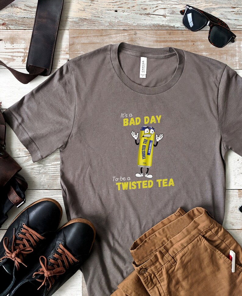 May include: A gray t-shirt with a yellow graphic of a Twisted Tea can with the text "It's a bad day to be a Twisted Tea".