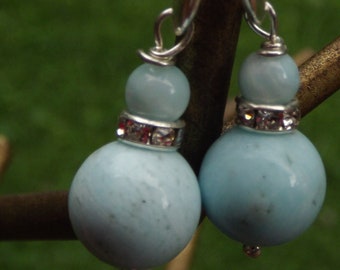 May include: A pair of dangle earrings with light blue gemstone beads and silver accents. The beads are round and have a textured surface.