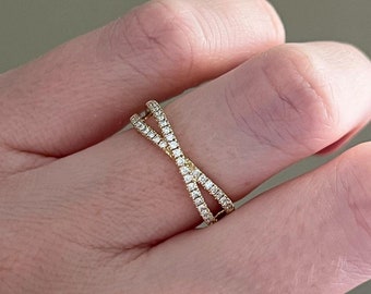 May include: A gold ring with a criss-cross design, set with small diamonds.