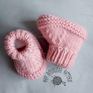 May include: A pair of light pink knitted baby booties featuring a ribbed cuff and a garter stitch border. The image includes the text CretaInlWonderland and PDF DOWNLOAD PATTERN with a graphic of a ball of yarn and knitting needles.