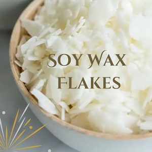 May include: A white bowl filled with soy wax flakes. The bowl is made of wood and has a white glaze. The text "SOY WAX FLAKES" is written in brown text on the flakes.