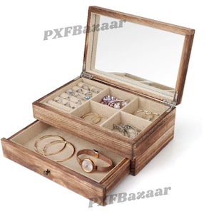 May include: A wooden jewelry box with a glass lid and a drawer. The box has a light brown finish and is filled with various jewelry, including rings, earrings, and a watch.