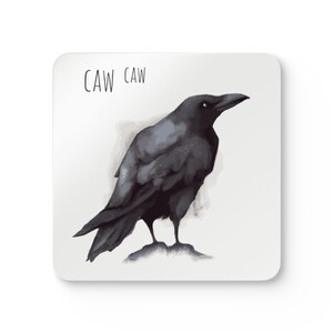 Op de afbeelding: Een zwarte raaf op een witte achtergrond. De tekst "CAW CAW" staat boven de raaf.