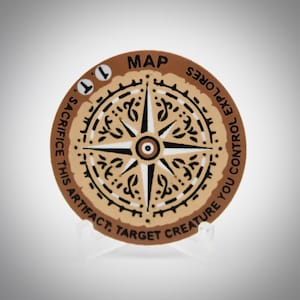 Peut inclure: Une carte de jeu ronde et beige avec un motif de rose des vents. La carte porte le mot "MAP" en haut et du texte sur le bord. La rose des vents est noire et blanche. La carte est présentée sur un support transparent.