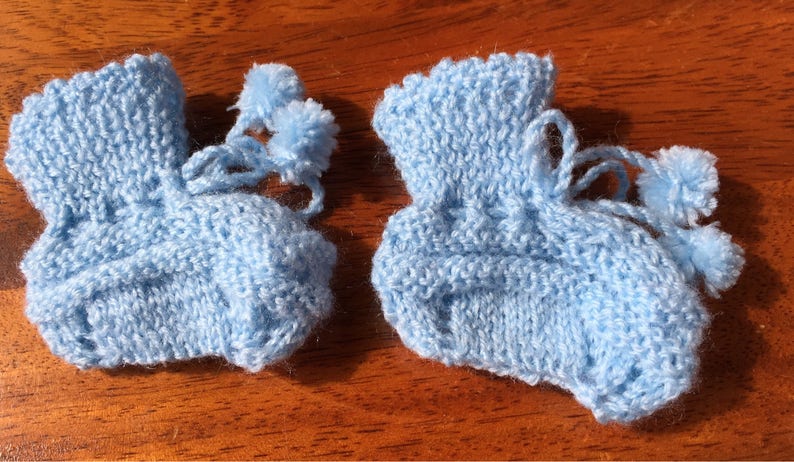 Hand knit baby booties with pompoms