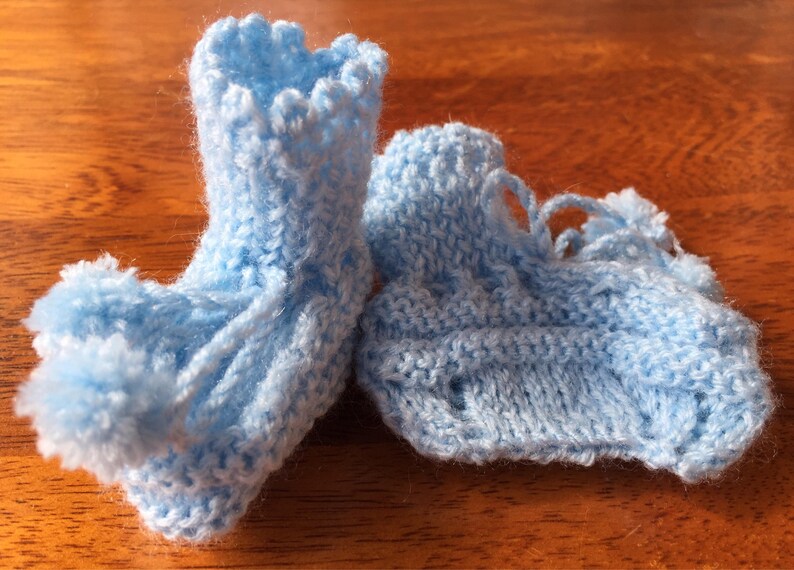 Hand knit baby booties with pompoms