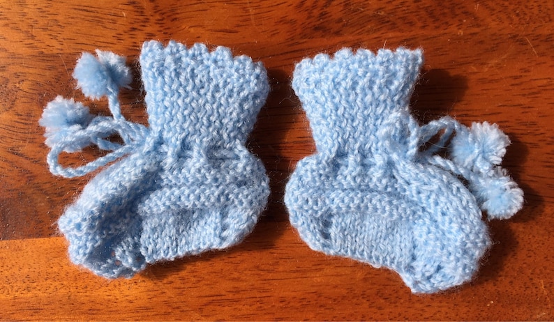 Hand knit baby booties with pompoms