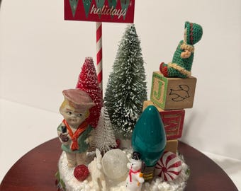 Handmade Vintage Christmas Assemblage, with Penny Doll, crocheted doll on abc blocks light bulb with deer among bottle brush trees