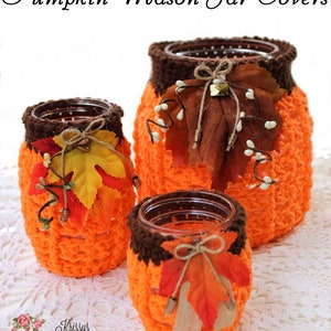 May include: Three crocheted pumpkin mason jar covers in orange and brown with fall leaves and twine accents. The jars are sitting on a white crocheted doily. The text "Pumpkin Mason Jar Covers" is at the top of the image. The text "Krissys Over The Mountain Crochet" is at the bottom of the image.