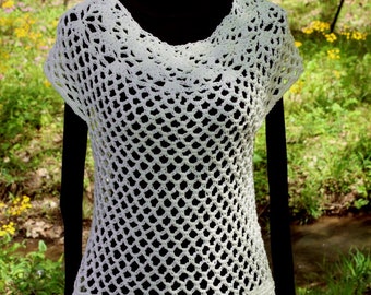 Peut inclure: Top en crochet blanc avec un design lâche et ajouré. Le haut a des manches courtes et un col rond. L'ourlet inférieur est fini par une bordure en crochet.