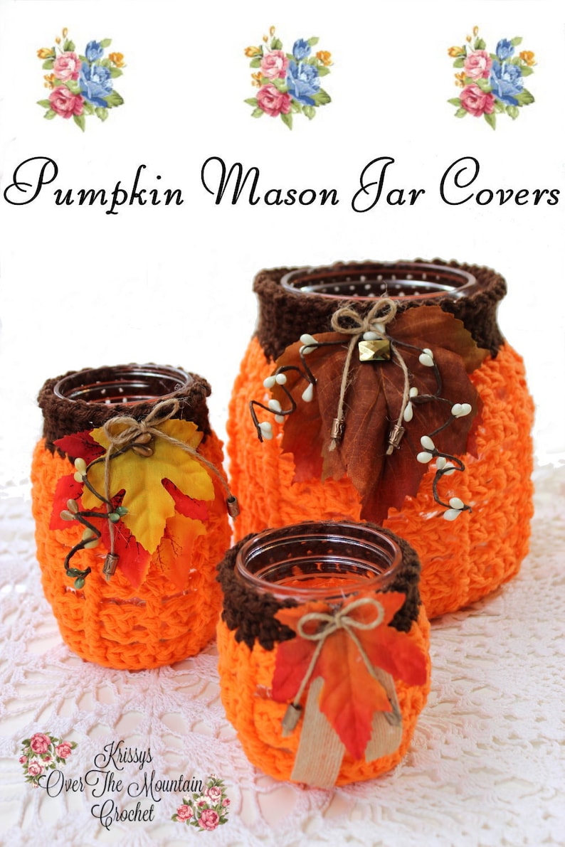 May include: Three crocheted pumpkin mason jar covers in orange and brown with fall leaves and twine accents. The jars are sitting on a white crocheted doily. The text "Pumpkin Mason Jar Covers" is at the top of the image. The text "Krissys Over The Mountain Crochet" is at the bottom of the image.
