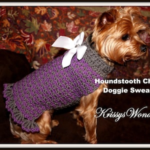 May include: A small dog wearing a handmade purple and gray houndstooth check dog sweater with a white bow. The sweater has a ruffled hem and collar. The text on the image reads "Houndstooth Check Doggie Sweater" and "Krissys Wonders".