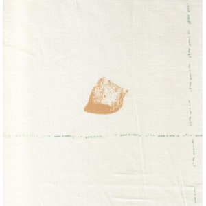 May include: A piece of off-white fabric with a tan-colored abstract shape in the center. A ruler with inch measurements is at the top. Faint green text and lines are visible.