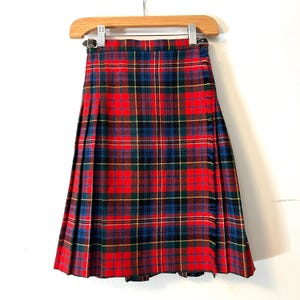Peut inclure: Une jupe de kilt en tartan rouge, bleu, vert et jaune avec un bord frangé.