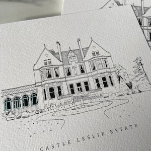 May include: A black and white line drawing of a large house with a fountain in front of it. The house has a long driveway and a large lawn. The text "CASTLE LESLIE ESTATE" is written below the house.