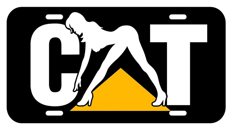 K&ouml;nnte beinhalten: Schwarzes Nummernschild mit dem Wort "CAT" in wei&szlig;en Blockbuchstaben. Eine wei&szlig;e Silhouette einer Frau befindet sich zwischen dem "C" und dem "T", mit einem gelben Dreieck darunter. Das Schild hat einen schwarzen Rand.