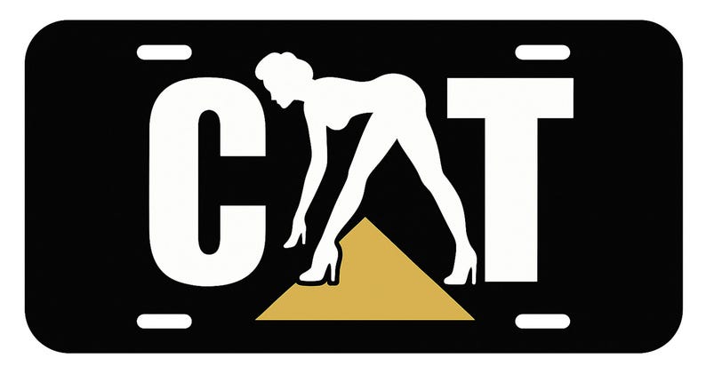 K&ouml;nnte beinhalten: Schwarzes Nummernschild mit dem Wort "CAT" in wei&szlig;en Blockbuchstaben. Eine wei&szlig;e Silhouette einer Frau in High Heels beugt sich. Ein goldfarbenes Dreieck befindet sich unter den F&uuml;&szlig;en der Frau. Das Nummernschild hat vier wei&szlig;e Schraubenl&ouml;cher.