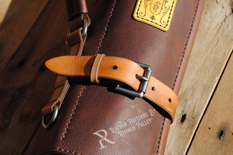 May include: Close-up of a brown leather bag with a light brown leather strap and a silver buckle. The bag has a decorative yellow tag. The text "Leather Patterns By Refined Pallet" is visible.
