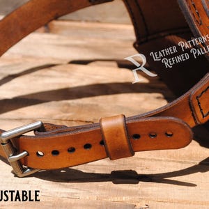 May include: A brown leather belt with a silver buckle and a stitched design. The belt is fully adjustable and has a  "Leather Patterns by Refined Pallet" label.