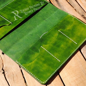 May include: Green leather wallet with white stitching and multiple card slots. The wallet is open and the inside is visible. The text "LEATHER PATTERNS BY REFINED PALLET" is printed on the front of the wallet.