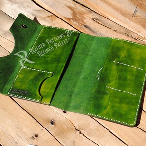 May include: Green leather wallet with white stitching and multiple card slots. The wallet is open and the inside is visible. The text "HANDCRAFTED BY REFINED PALLET" is printed on the inside of the wallet.