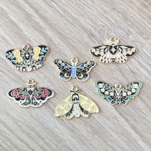 4 piezas de dijes de polilla o mariposa esmaltados con motivos florales oscuros - Negro, rosa, amarillo agua - 30 mm