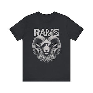 May include: Black t-shirt with a white graphic of a ram wearing sunglasses and the word "RAMS" above it.