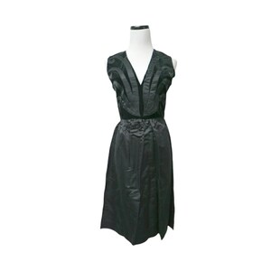 Puede incluir: Un vestido negro sin mangas con escote en V y un diseño decorativo en el corpiño.