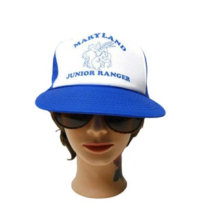 May include: Blue and white trucker hat with the text "Maryland Junior Ranger" and a blue illustration of a squirrel and a rabbit on the front.